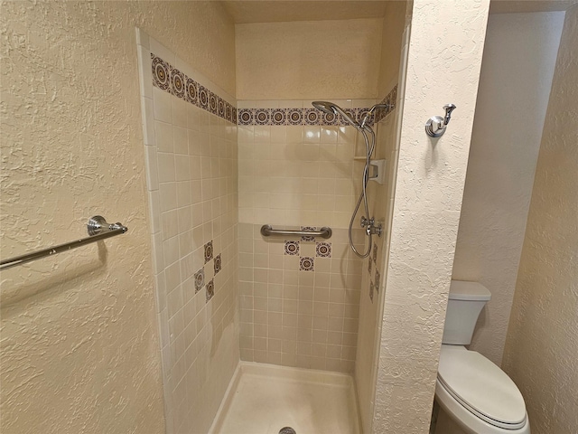 bathroom with toilet and tiled shower