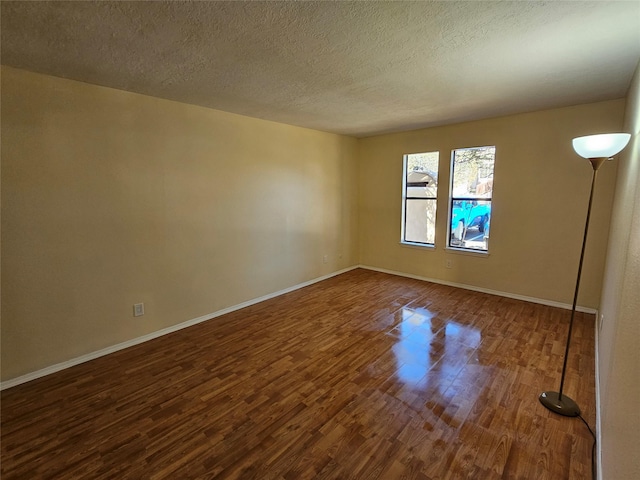 empty room featuring dark wood-type flooring and a textured ceiling