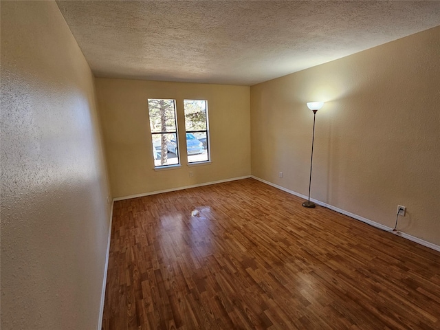 unfurnished room with hardwood / wood-style floors and a textured ceiling