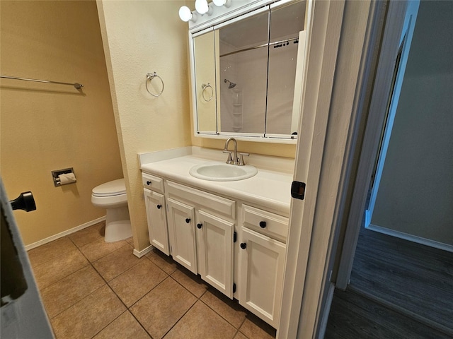 bathroom with tile patterned flooring, vanity, and toilet