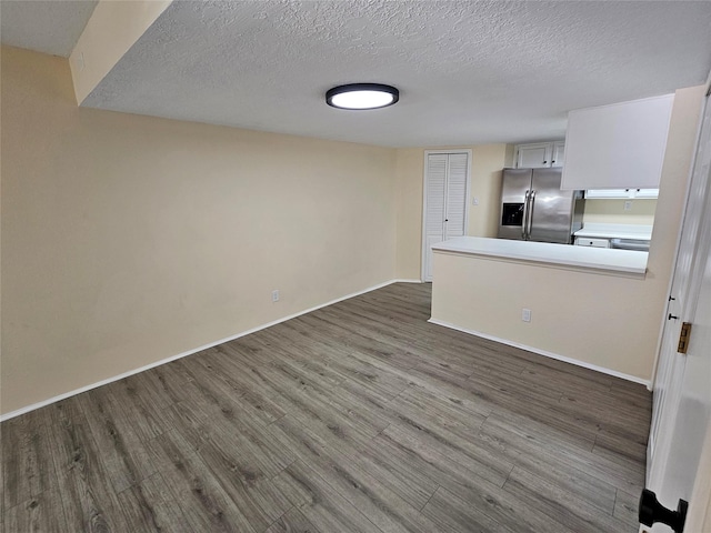 interior space with a textured ceiling and dark hardwood / wood-style flooring