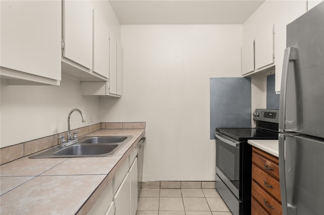 kitchen with stainless steel appliances, white cabinetry, sink, and light tile patterned floors