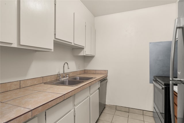 kitchen with white cabinetry, sink, light tile patterned floors, and stainless steel appliances