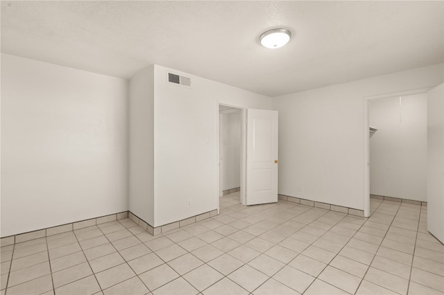 tiled spare room featuring a textured ceiling