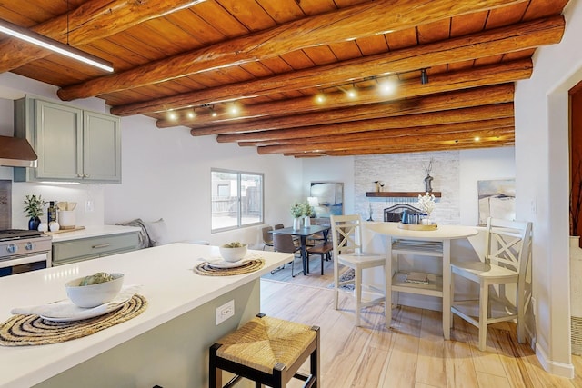 kitchen featuring wood ceiling, stainless steel range with gas cooktop, gray cabinets, beamed ceiling, and light hardwood / wood-style floors