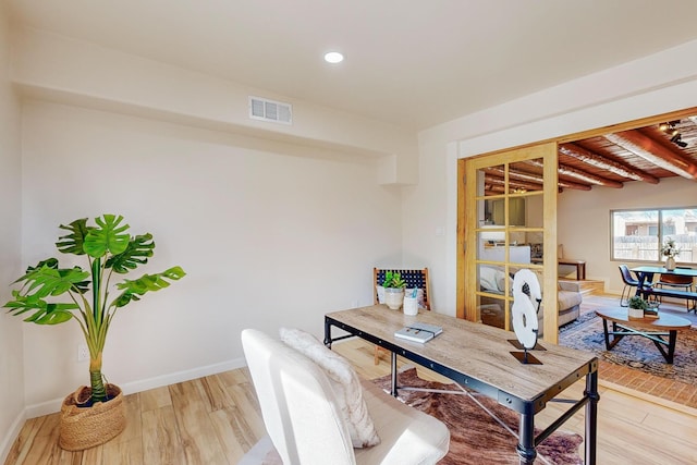 office featuring hardwood / wood-style floors and beam ceiling