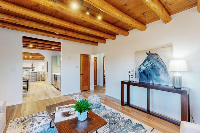 living room with wood ceiling, beamed ceiling, and light wood-type flooring