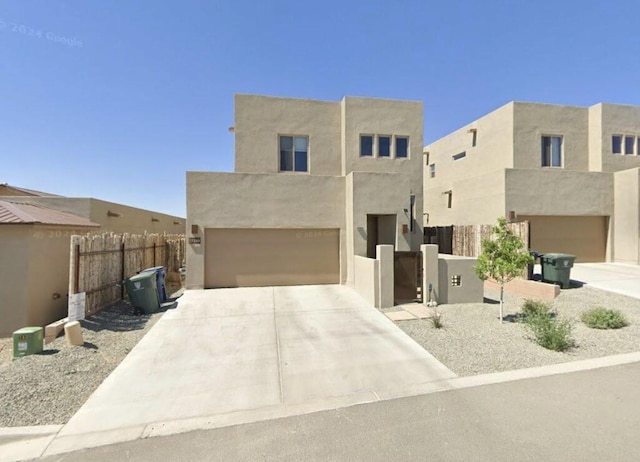 pueblo revival-style home with a garage