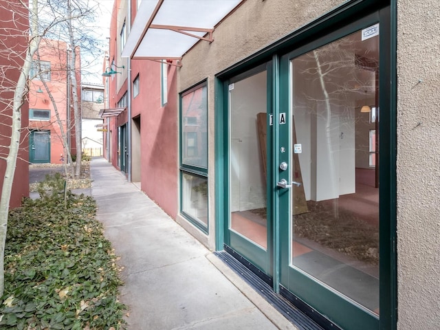 doorway to property featuring stucco siding