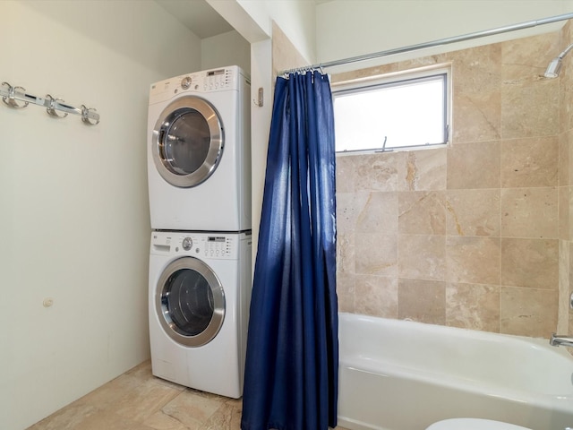 washroom with stacked washer and dryer and laundry area