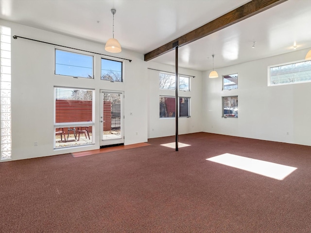 carpeted spare room featuring beamed ceiling