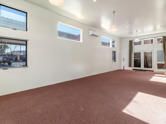 unfurnished living room featuring an AC wall unit and carpet flooring