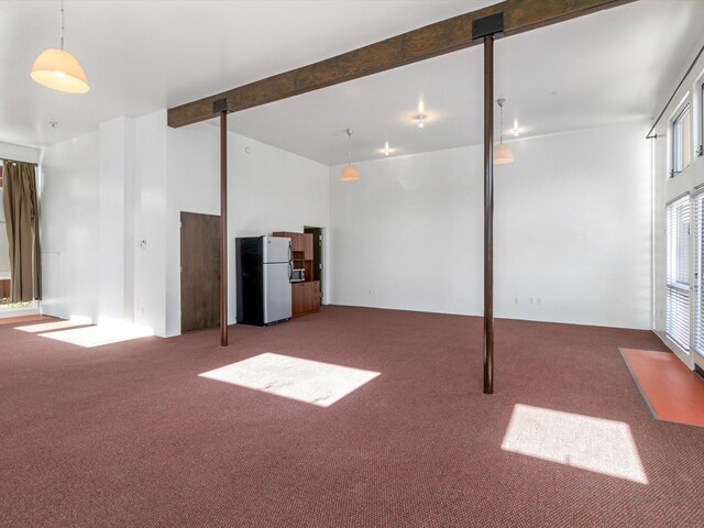 below grade area featuring freestanding refrigerator and carpet floors