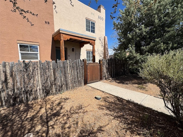 2210 Miguel Chavez Rd Unit 815, Santa Fe, NM 87505 - view of home's exterior featuring a gate, fence, and stucco siding
