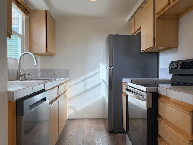 kitchen with sink, light brown cabinets, stainless steel appliances, and light wood-type flooring