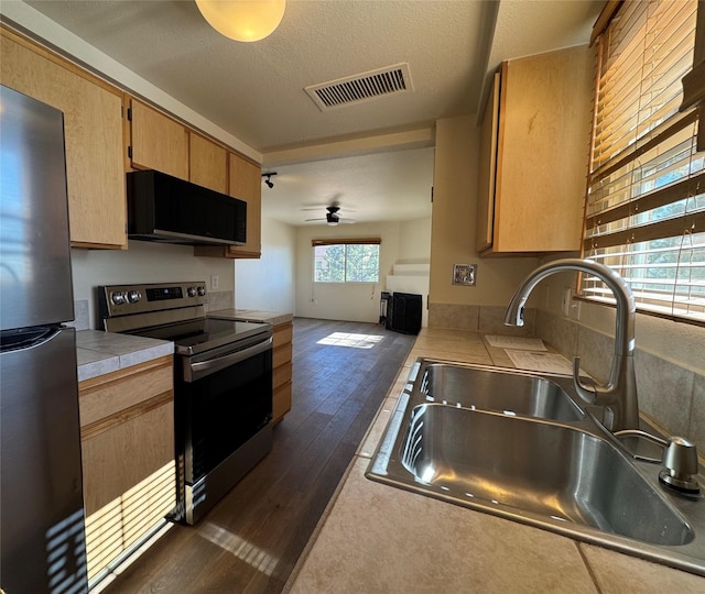 2210 Miguel Chavez Rd Unit 815, Santa Fe, NM 87505 - kitchen featuring a sink, ceiling fan, appliances with stainless steel finishes, dark wood-type flooring, and visible vents