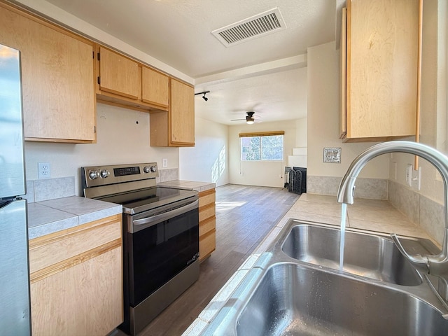 kitchen featuring sink, tile countertops, light brown cabinets, dark hardwood / wood-style floors, and stainless steel appliances