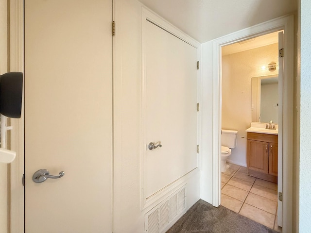 corridor with sink and light tile patterned floors