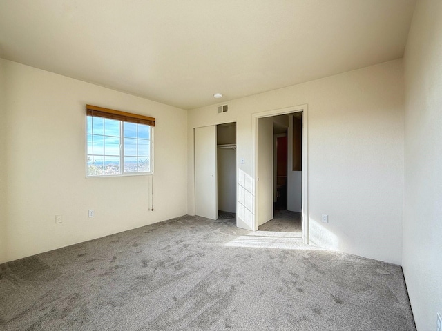 unfurnished bedroom with a closet and carpet flooring