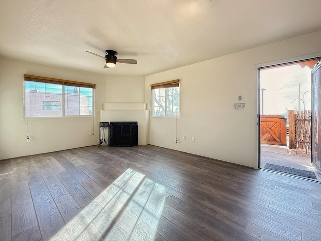 unfurnished living room featuring hardwood / wood-style flooring, a textured ceiling, and ceiling fan