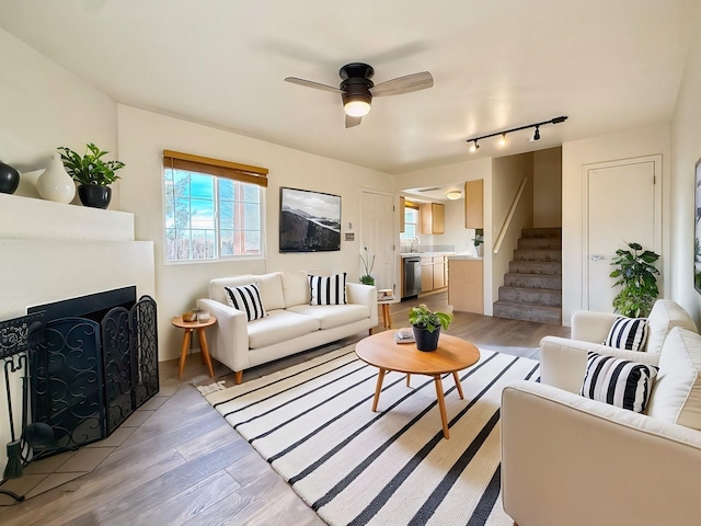 living room with ceiling fan, sink, and light hardwood / wood-style floors