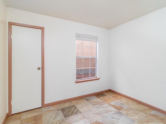 unfurnished room with a textured ceiling