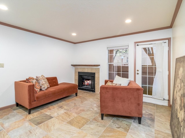 living room featuring crown molding and a tiled fireplace