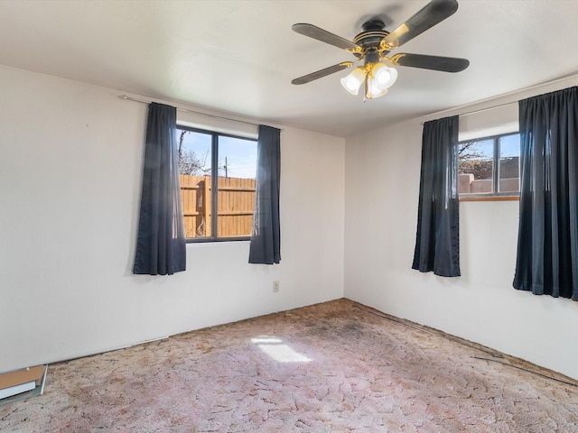 spare room with carpet, a healthy amount of sunlight, and ceiling fan