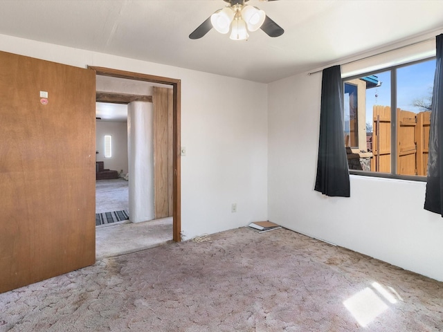 carpeted spare room featuring ceiling fan