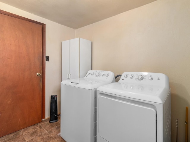 clothes washing area featuring cabinets and washing machine and clothes dryer