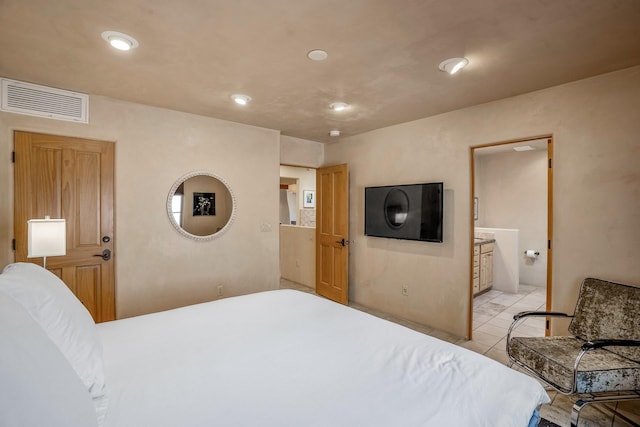 bedroom with ensuite bath and light tile patterned flooring