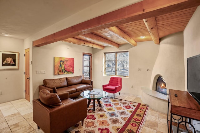 living room featuring beamed ceiling, light tile patterned flooring, a large fireplace, and wooden ceiling