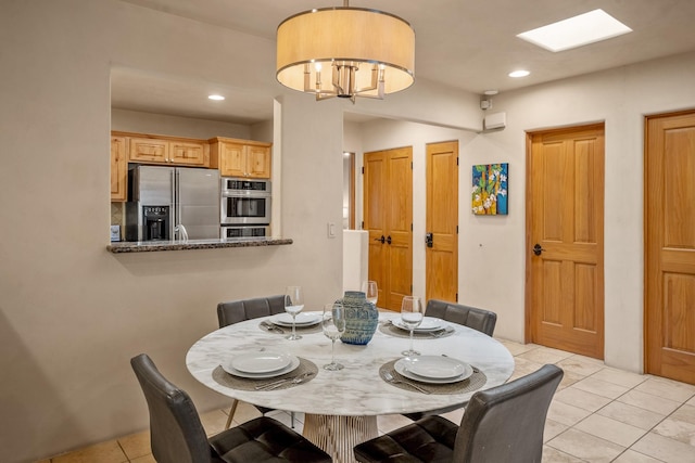 dining area with light tile patterned flooring and a notable chandelier