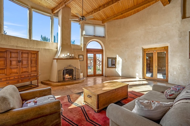 living room with vaulted ceiling with beams, a fireplace, wooden ceiling, and french doors