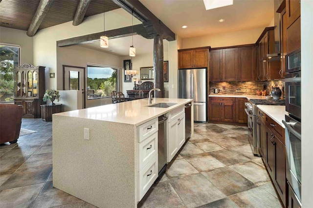 kitchen with a sink, hanging light fixtures, appliances with stainless steel finishes, decorative backsplash, and beamed ceiling