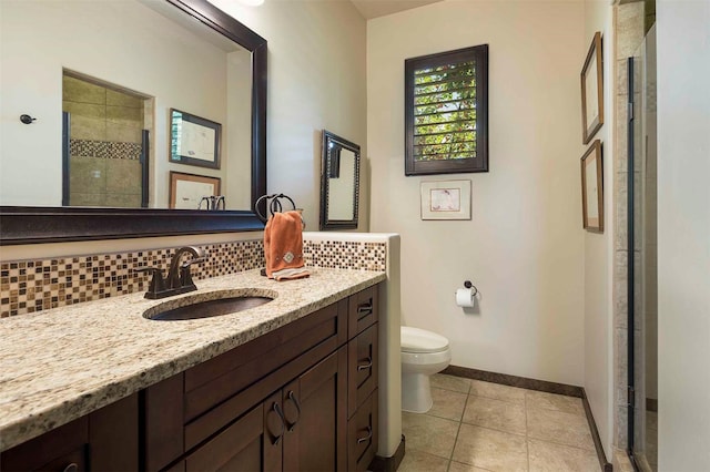 full bath featuring a stall shower, baseboards, decorative backsplash, toilet, and vanity