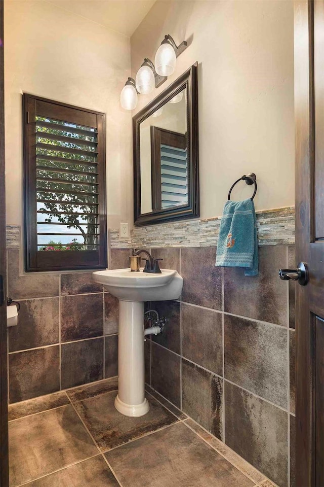 bathroom with wainscoting and tile walls