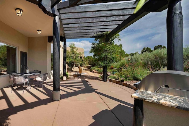 view of patio featuring exterior kitchen, a pergola, and outdoor dining space