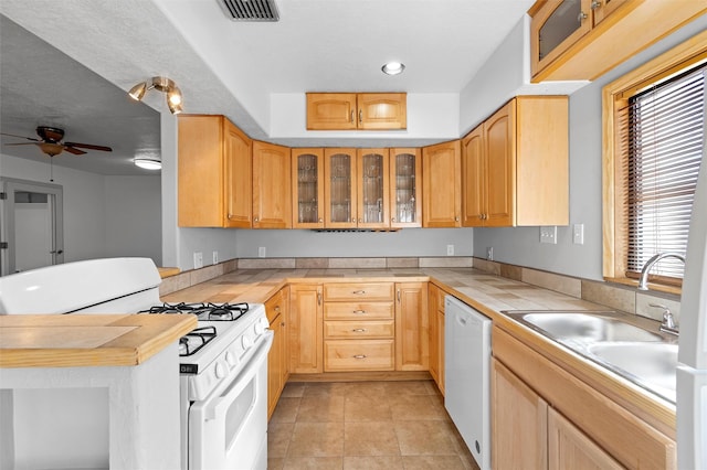 kitchen featuring light brown cabinetry, light tile patterned floors, and white appliances