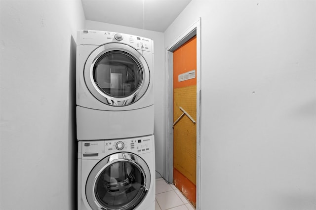 laundry area featuring stacked washing maching and dryer and light tile patterned flooring