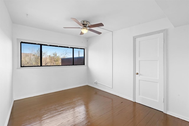 empty room with dark hardwood / wood-style floors and ceiling fan