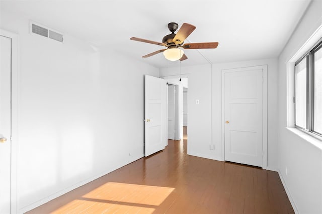 unfurnished bedroom with dark wood-type flooring and ceiling fan