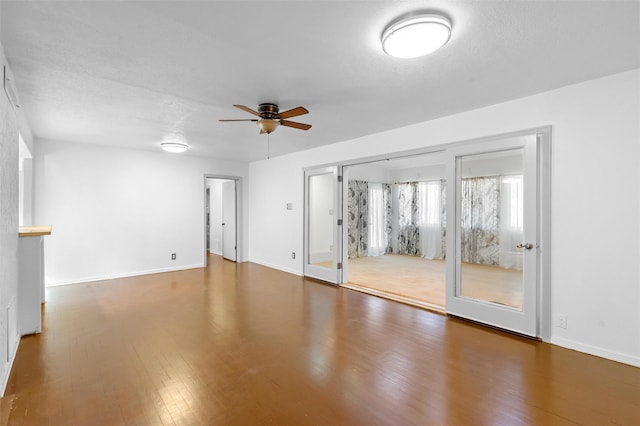 empty room featuring dark hardwood / wood-style flooring, a textured ceiling, and ceiling fan