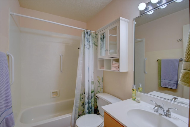 full bathroom featuring shower / bath combination with curtain, vanity, toilet, and a textured ceiling