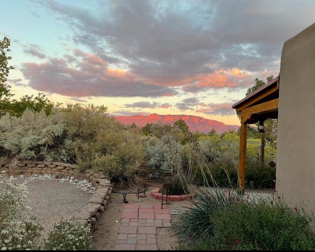 patio terrace at dusk featuring a mountain view