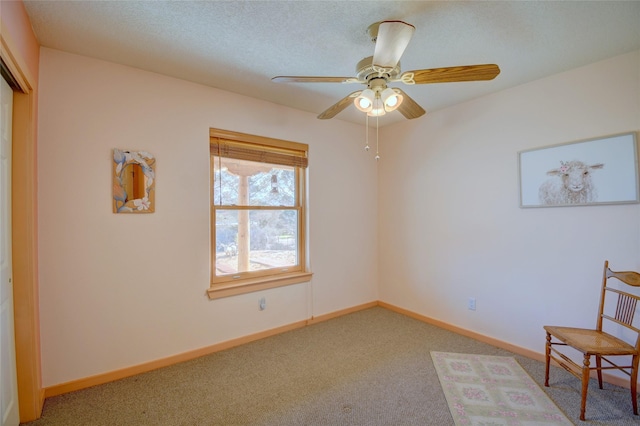 living area with a textured ceiling, ceiling fan, and carpet flooring