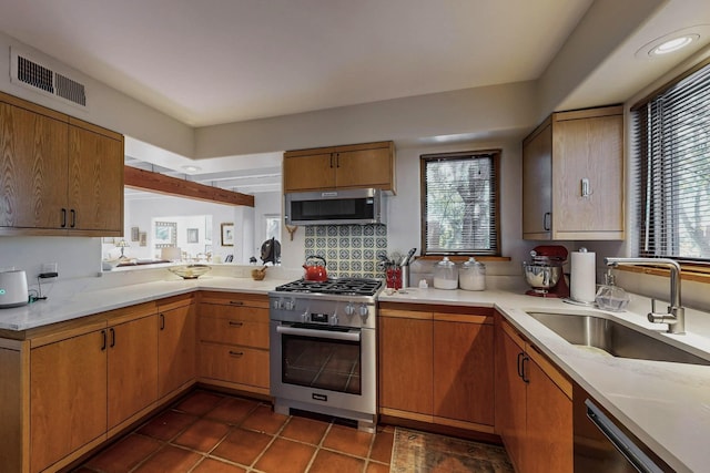 kitchen with stainless steel appliances, dark tile patterned flooring, and sink