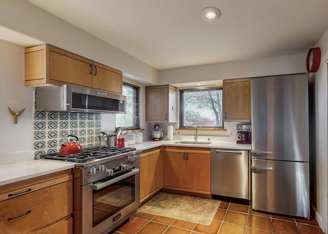 kitchen featuring sink, decorative backsplash, stainless steel appliances, and dark tile patterned floors