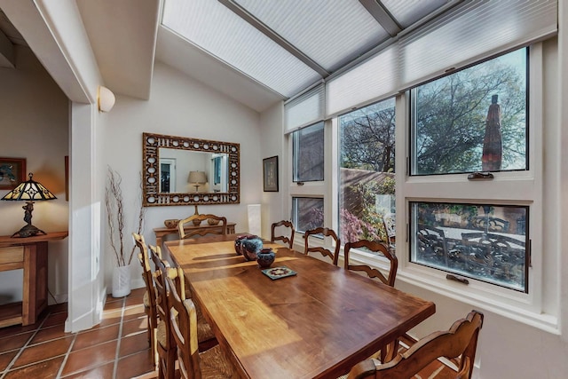 tiled dining room with expansive windows, vaulted ceiling, and plenty of natural light