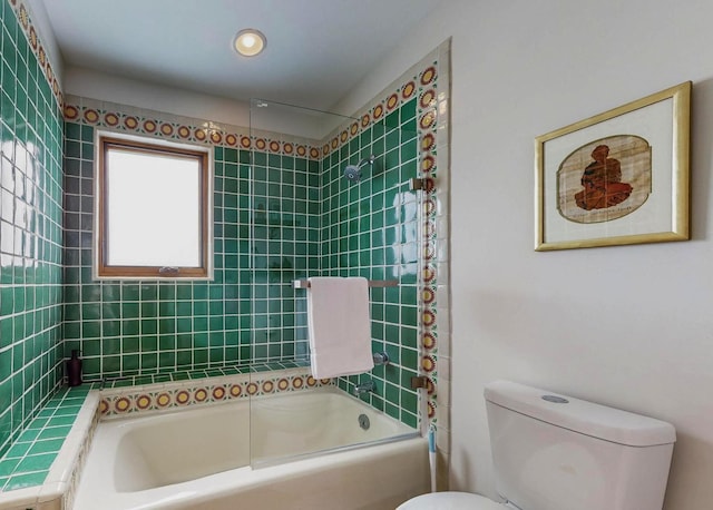 bathroom with toilet and tiled shower / bath combo